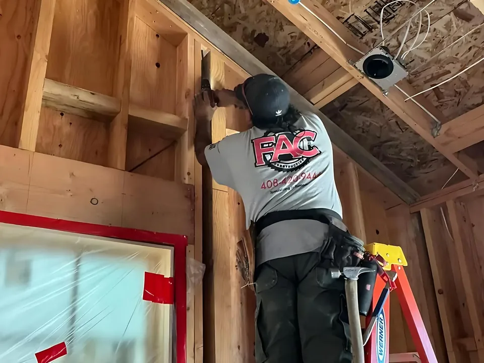 FAC Construction crew member framing a house on a ladder
